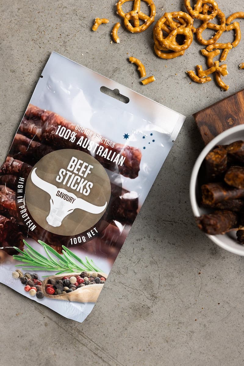 Pouch of beef sticks on table next to pretzels