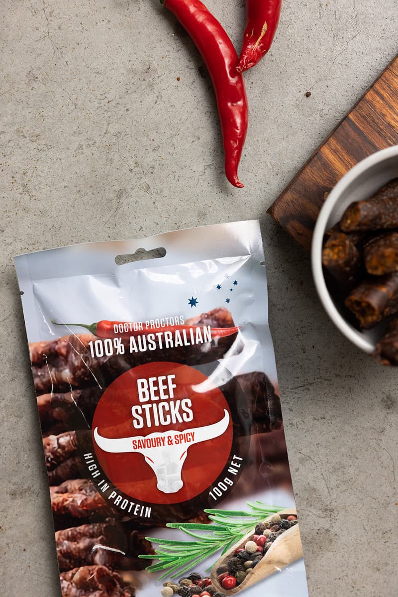 Pouch of beef sticks on table next to red chillis