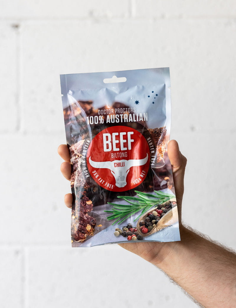 hand holding chilli beef biltong up in the air