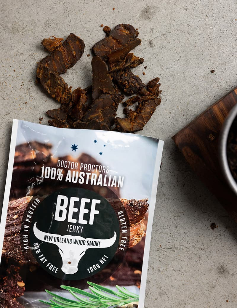 Wood smoked beef jerky on ground with smoked jerky next to it