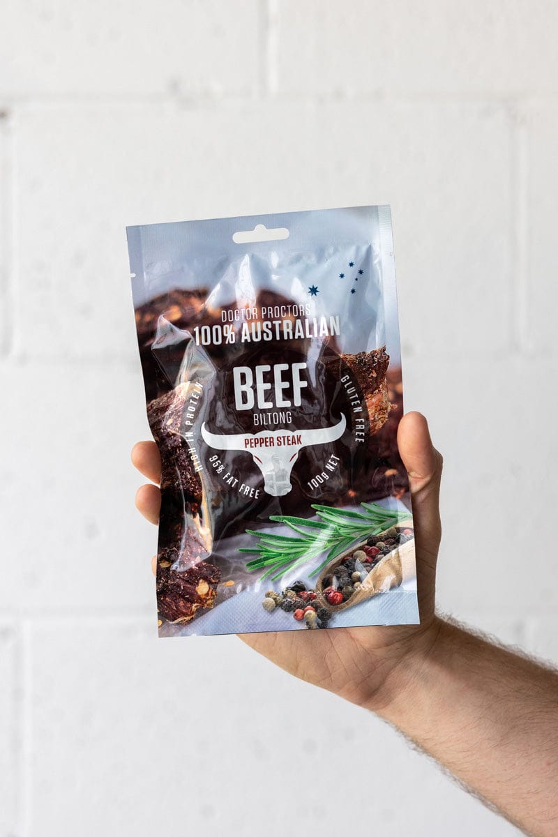 Hand holding large pouch of biltong up in the air
