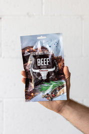 Hand holding large pouch of biltong up in the air