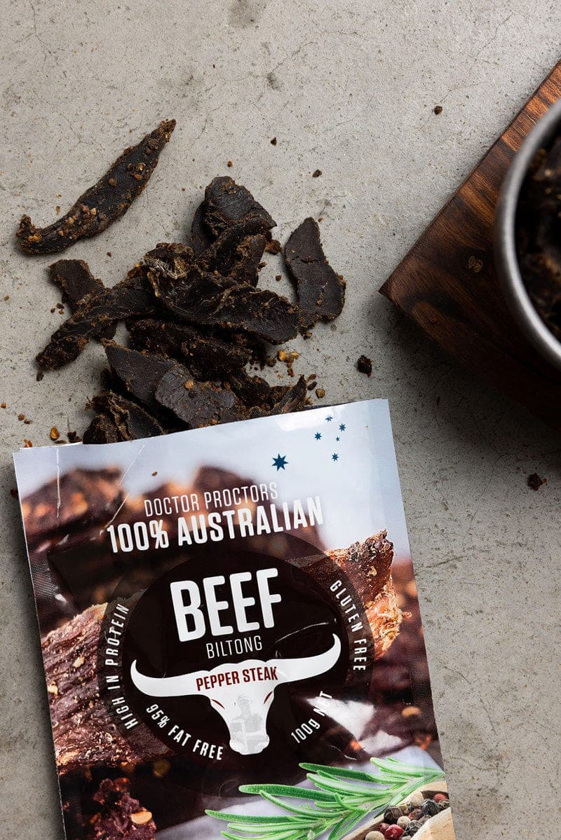 Juicy pepper steak biltong next to a pouch of biltong flatlay