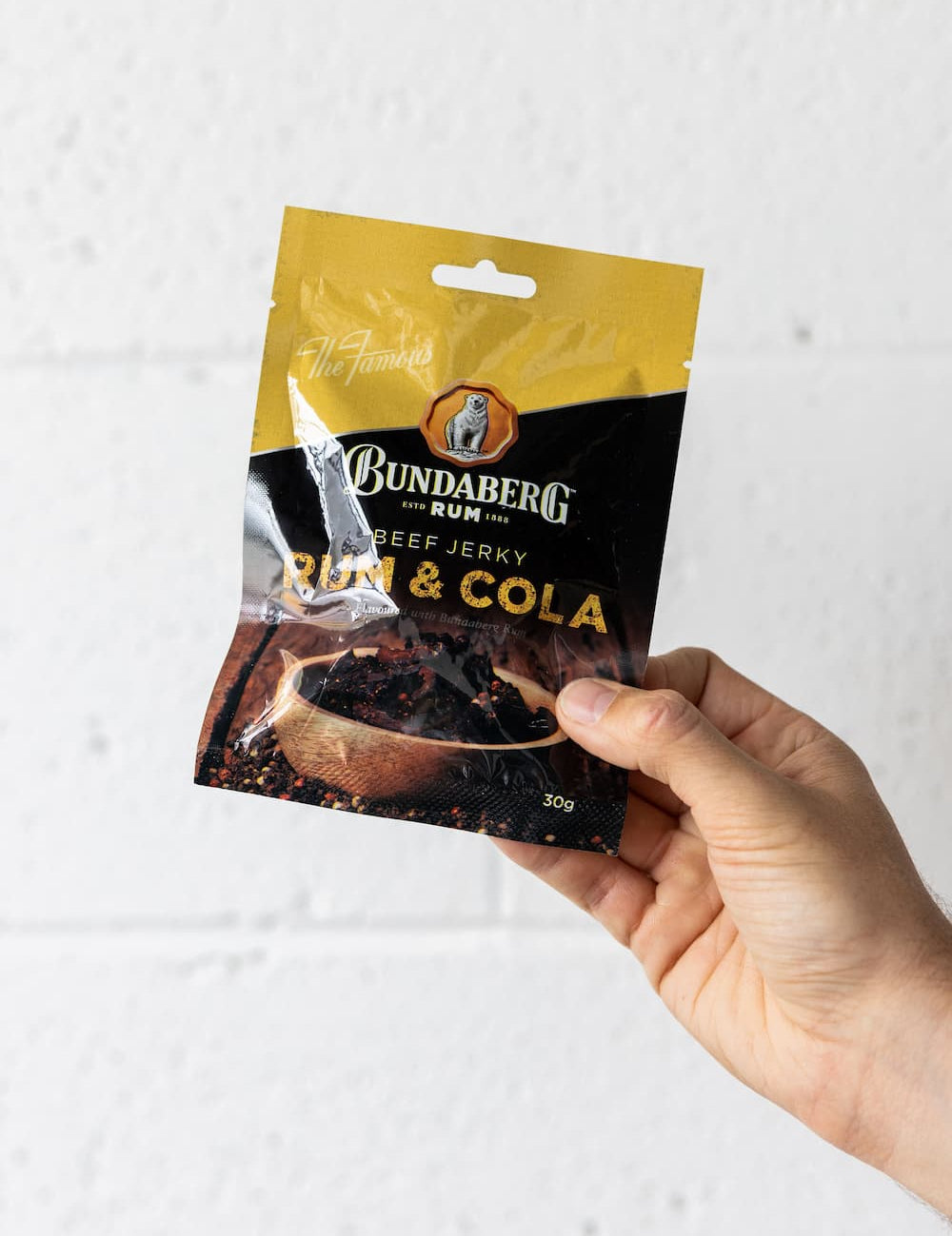 Hand holding packet of beef jerky up in the air