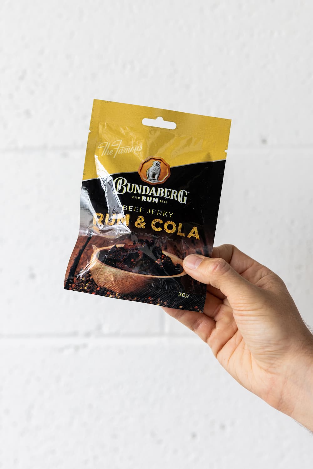 Hand holding packet of beef jerky up in the air