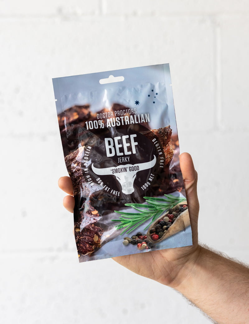 Hand holding beef jerky up in the air