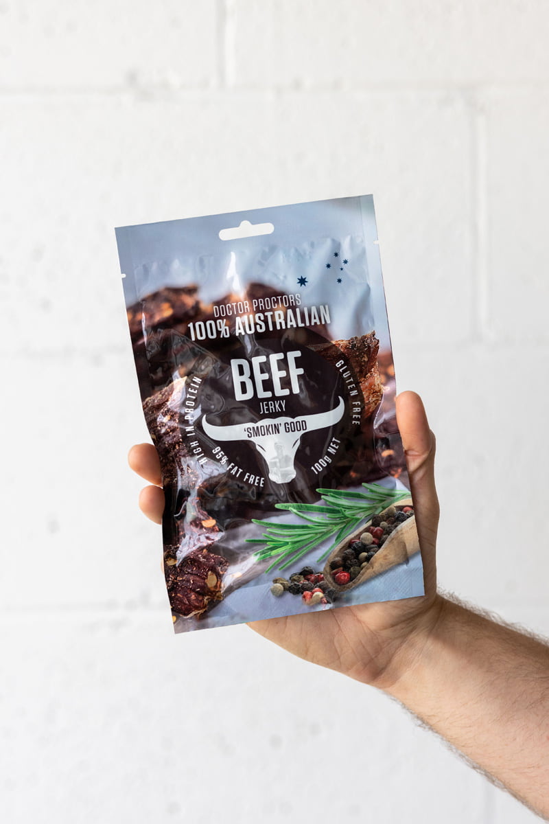 Hand holding beef jerky up in the air