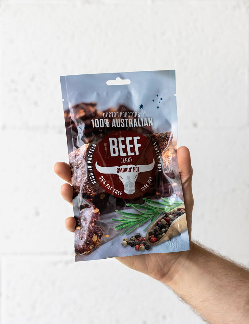 Hand holding pouch of beef jerky in the air