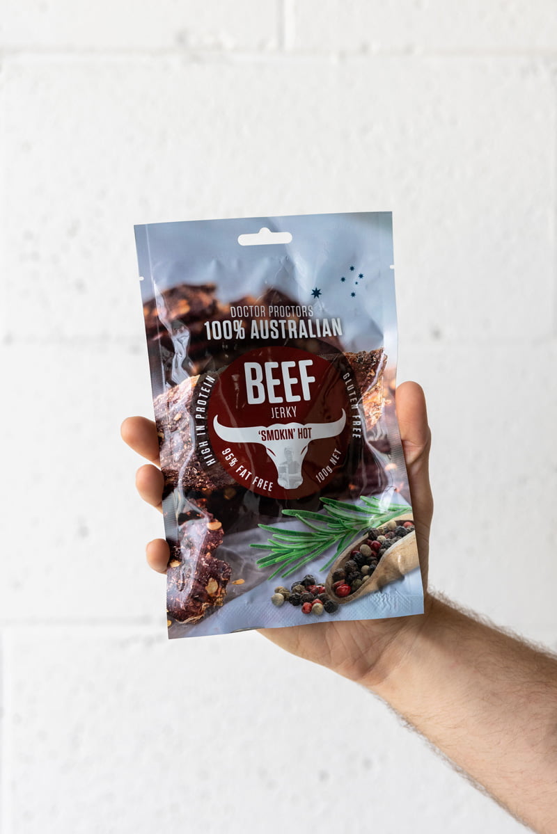 Hand holding pouch of beef jerky in the air