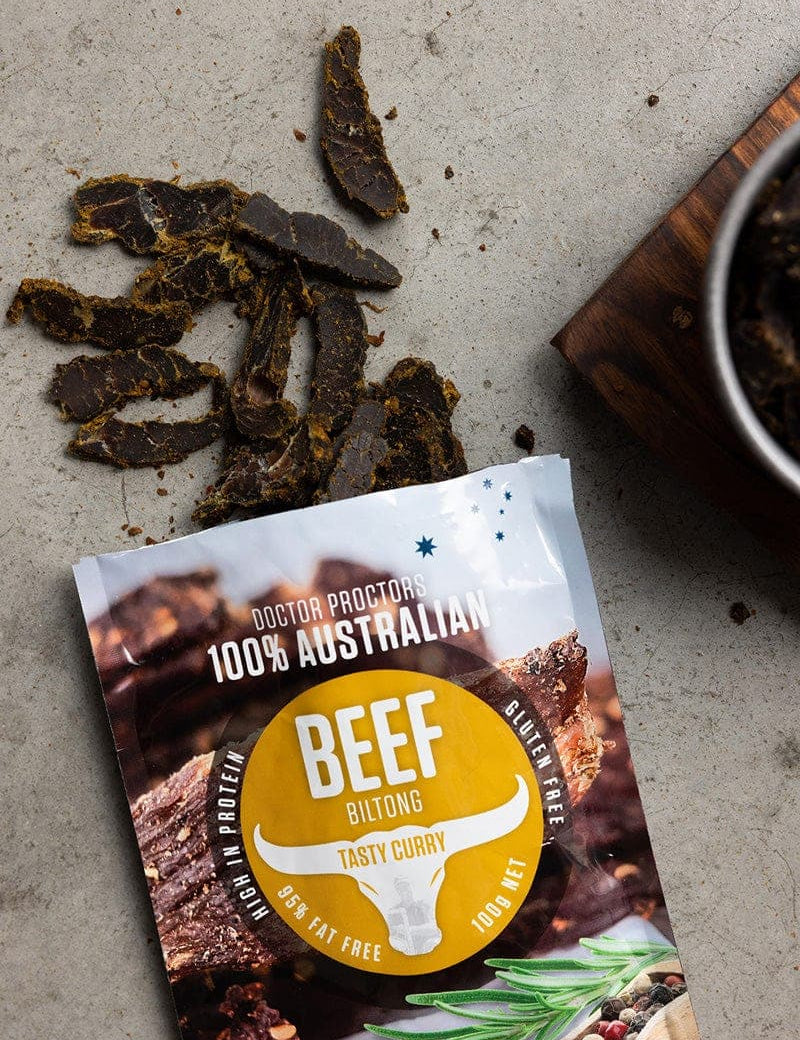 Tasty Curry biltong on the ground flatlay next to a bowl of tasty curry biltong