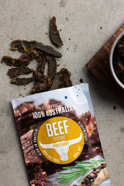 Tasty Curry biltong on the ground flatlay next to a bowl of tasty curry biltong