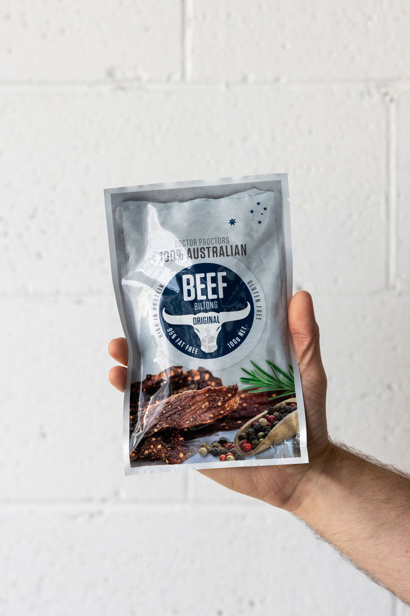 Hand holding large pouch of original beef biltong