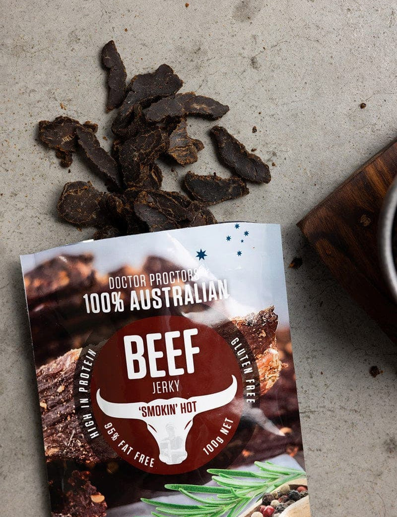 Beef jerky pouch on ground flatlay with pieces of loose jerky next to it