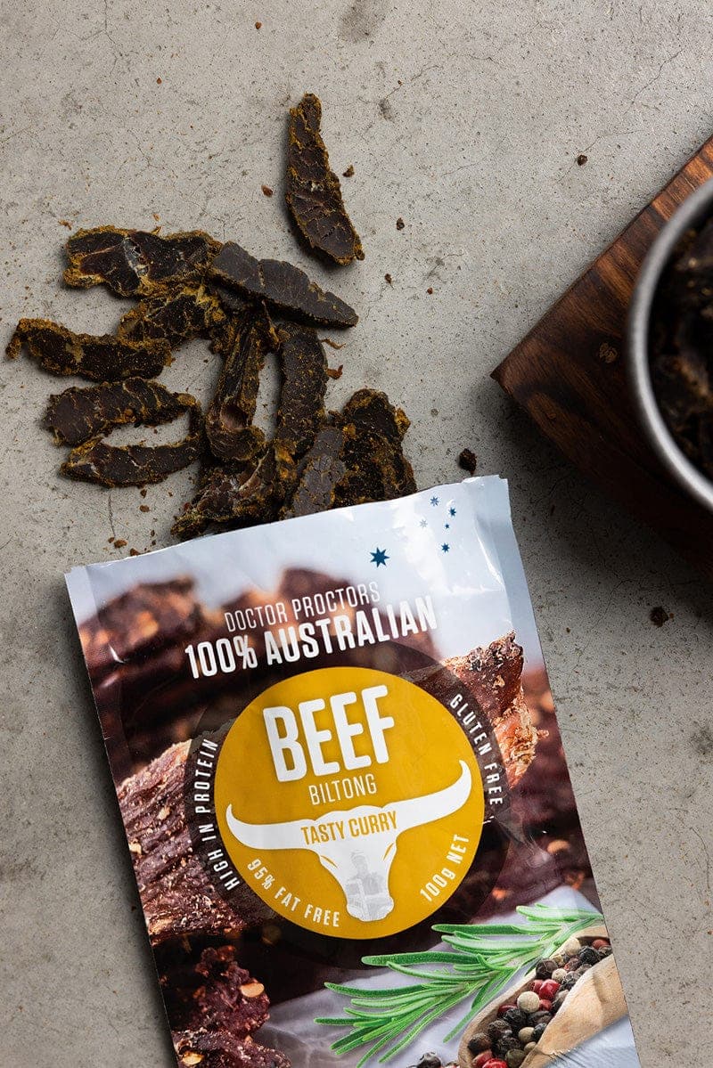 Tasty Curry biltong on the ground flatlay next to a bowl of tasty curry biltong