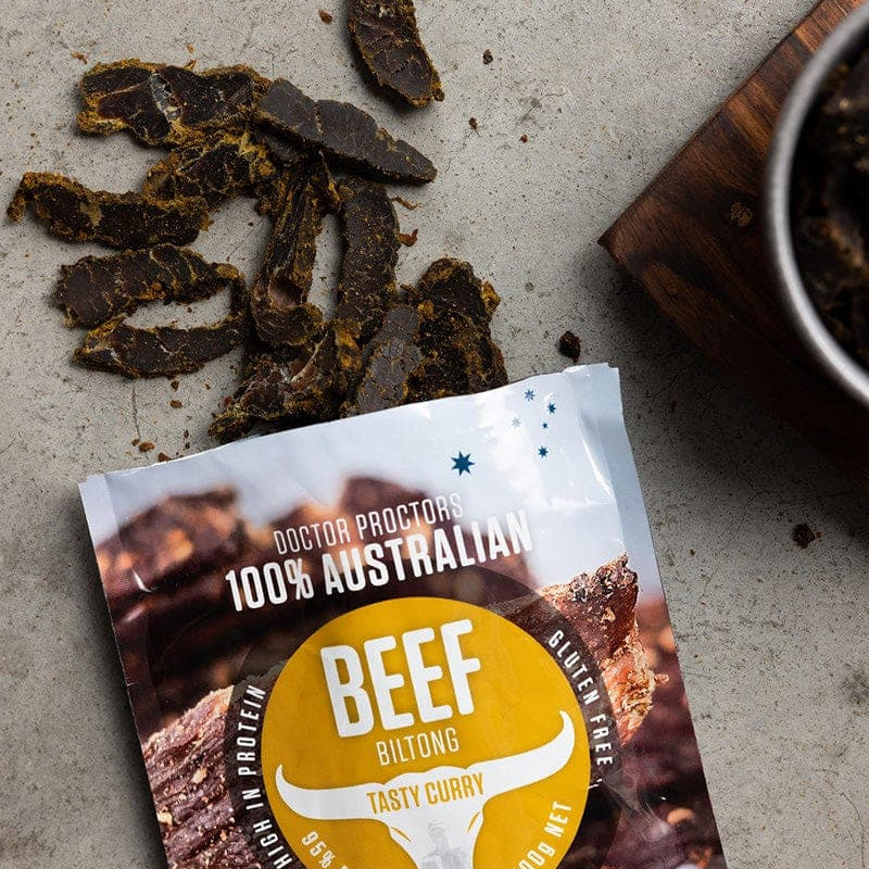 Tasty Curry biltong on the ground flatlay next to a bowl of tasty curry biltong